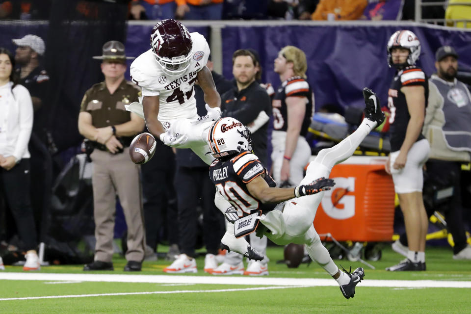 Texas A&M defensive back Kent Robinson, left, defends on an incomplete pass to Oklahoma State wide receiver Brennan Presley during the first half of the Texas Bowl NCAA college football game Wednesday, Dec. 27, 2023, in Houston. (AP Photo/Michael Wyke)