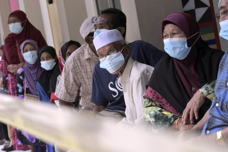 Voters wearing face masks to help curb the spread of the coronavirus wait for their turn at a polling station during a state election on the outskirts of Kota Kinabalu, in Malaysia's Sabah state on Borneo island, Saturday, Sept. 26, 2020. Polls opened Saturday in Malaysia's eastern Sabah state in a vote seen as a referendum for embattled Prime Minister Muhyiddin Yassin's 7-month-old unelected government. (AP Photo)