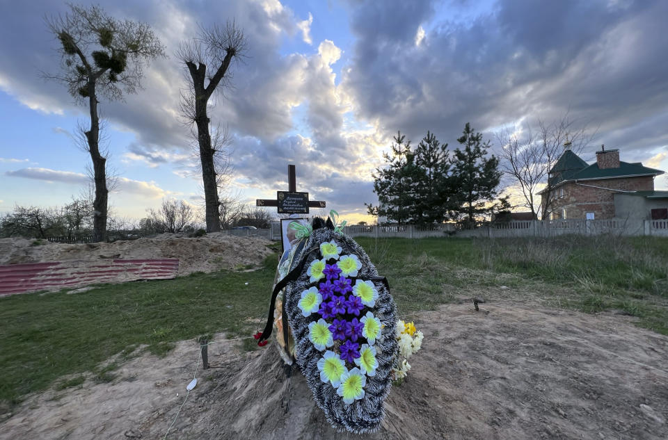 Flowers lie on the grave of Andrii Voznenko in the village of Ozera, Ukraine, near Bucha, on April 30, 2022. On March 21, 2022, Russian soldiers took him away after he confessed to relaying information about Russian troops to Ukrainian forces, after a Russian held a gun to his head. (AP Photo/Erika Kinetz)