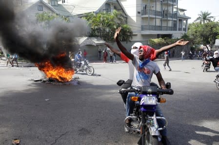 Protesters gesture in front of Haitian National Police (PNH) officers (not pictured) during a demonstration to demand the resignation of Haitian president Jovenel Moise, in the streets of Petion Ville, Port-au-Prince