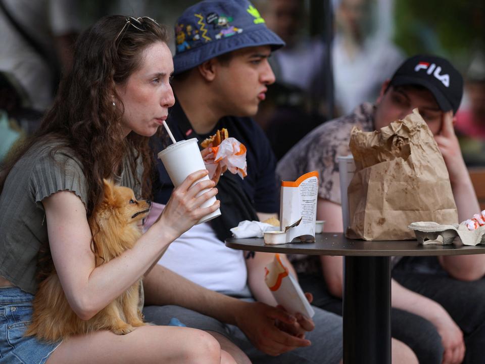 A customer holds a dog while having a meal at the new restaurant "Vkusno & tochka", which opens following McDonald's Corp company's exit from the Russian market, in Moscow, Russia June 12, 2022.