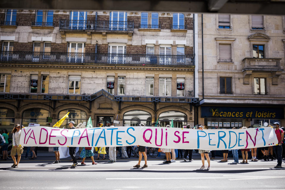 Protesters walk with a banner during a demonstration against the World Trade Organization (WTO) in Geneva, Switzerland, Saturday, June 11, 2022. For the first time in 4 1/2 years, after a pandemic pause, government ministers from WTO countries will gather for four days starting Sunday. (Valentin Flauraud/Keystone via AP)