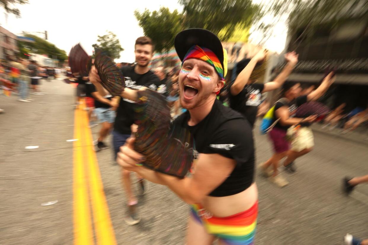 Members of Disney Pride in Concert cheer and wave to fans during the WeHo Pride Parade in West Hollywood on Sunday.