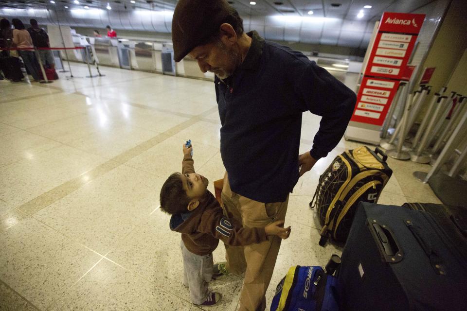 En esta imagen, tomada el 17 de marzo de 2017, Franklin Pérez habla con su hijo Ezra mientras esperan para partir hacia Bogotá, antes de ir a Israel, en el aeropuerto internacional Simón Bolívar, en Maiquetia, Venezuela. Pérez admite libremente que de no ser por el colapso venezolano nunca habría intentado irse. (AP Foto/Fernando Llano)