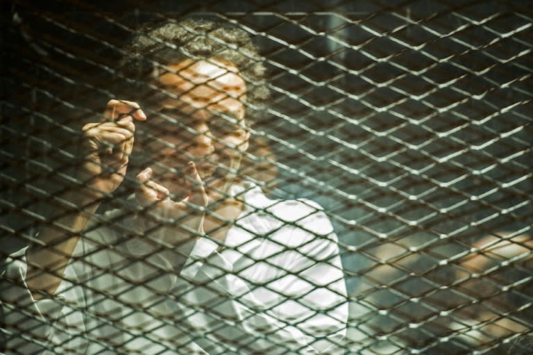 Mahmoud Abu Zeid mimics taking a photograph during his trial at the Cairo Criminal Court on September 8