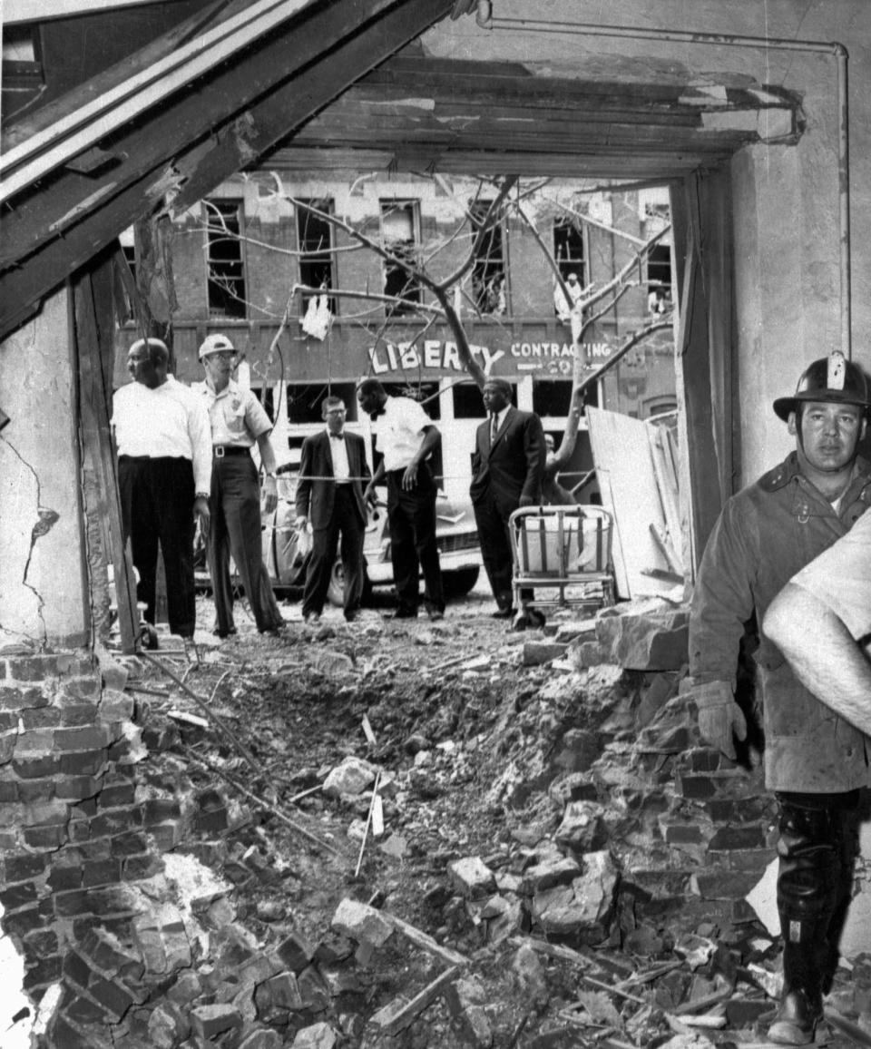 In this Sept. 15, 1963 file photo, emergency workers and others stand around a large crater from a bomb which killed four Black girls in the Sixteenth Street Baptist Church in Birmingham, Ala. The windows of the building across the street in the background were also blown out.