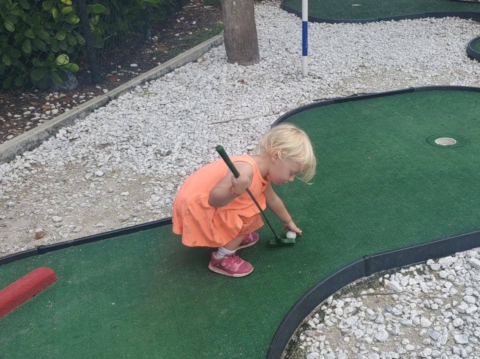 Christopher Mannino's child playing mini golf