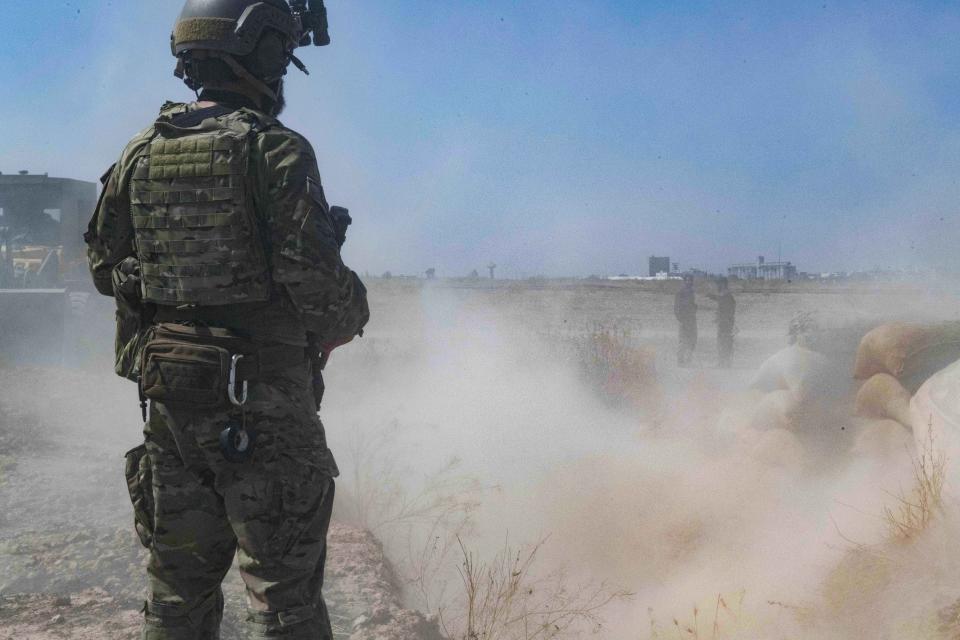 In this Sept. 21, 2019, photo, released by the U.S. Army, a U.S. soldier oversees members of the Syrian Democratic Forces as they demolish a Kurdish fighters' fortification as part of the so-called "safe zone" near the Turkish border. (U.S. Army photo by Staff Sgt. Andrew Goedl via AP)