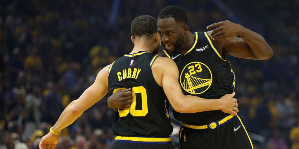 Stephen Curry and Draymond Green hug during a game.