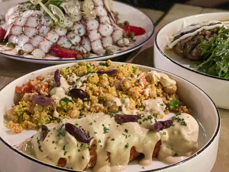 bowls of greek food sitting on table at Taverna Greek Kitchen in Dubai