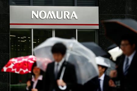 People walk past a branch of the Nomura financial services group in Tokyo, Japan, April 28, 2016. REUTERS/Thomas Peter