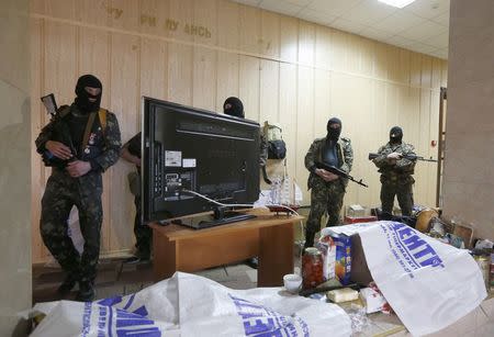 Pro-Russian armed men stand in the seized regional prosecutor's office in Luhansk, eastern Ukraine, April 30, 2014. REUTERS/Vasily Fedosenko