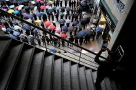 A man takes a photographs of people waiting in a line to buy masks in front of a department store in Seoul