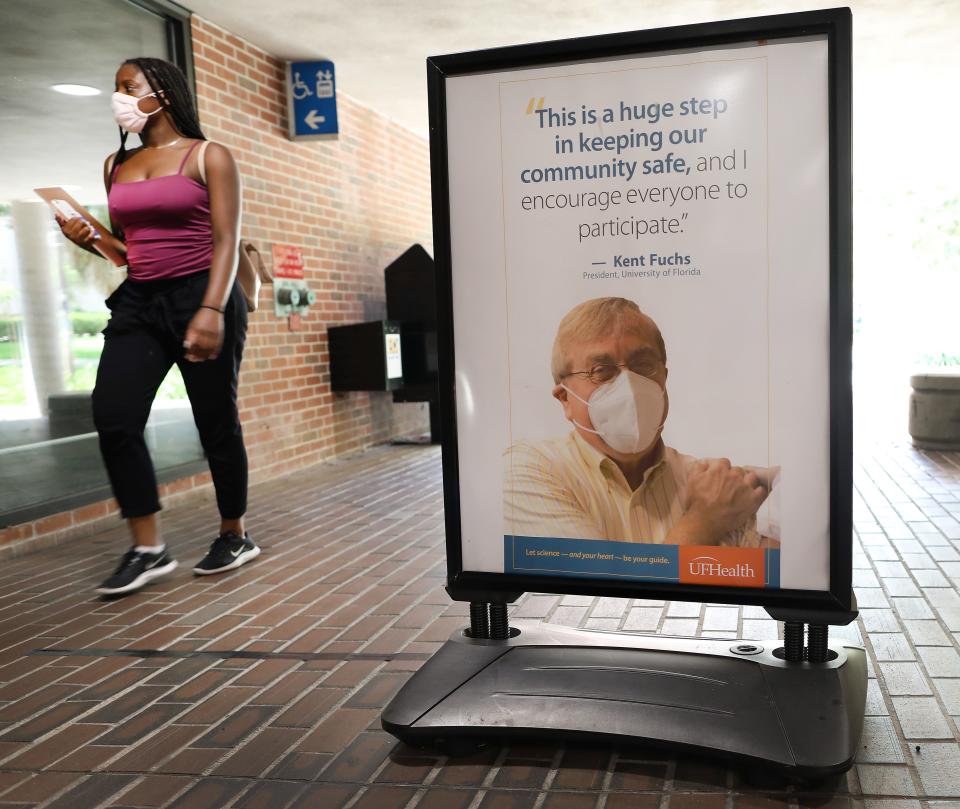 A student walks past a poster of University of Florida President Kent Fuchs encouraging student to get vaccinated against COVID-19 at Weimer Hall on the UF campus in Gainesville in 2021.