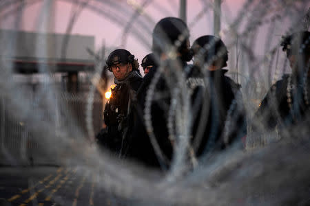 U.S. Customs and Border Protection (CBP) Special Response Team (SRT) officers are seen through concertina wire at the San Ysidro Port of Entry after the land border crossing was temporarily closed to traffic in Tijuana, Mexico November 19, 2018. REUTERS/Adrees Latif