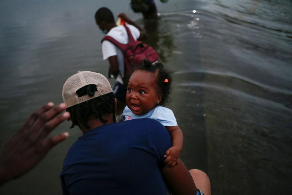 Migrants seeking asylum walk into the Rio Grande river to cross the border between Ciudad Acuna, Mexico and Del Rio, in Texas, U.S., after buying supplies at the Mexican side, in Ciudad Acuna, Mexico, September 18, 2021.