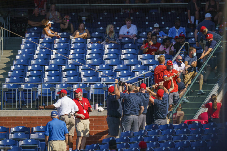 Philadelphia Phillies' ground crew pull the rope to fix the safety netting that snapped during the eighth inning of a baseball game against the Washington Nationals, Sunday, June 6, 2021, in Philadelphia. (AP Photo/Chris Szagola)