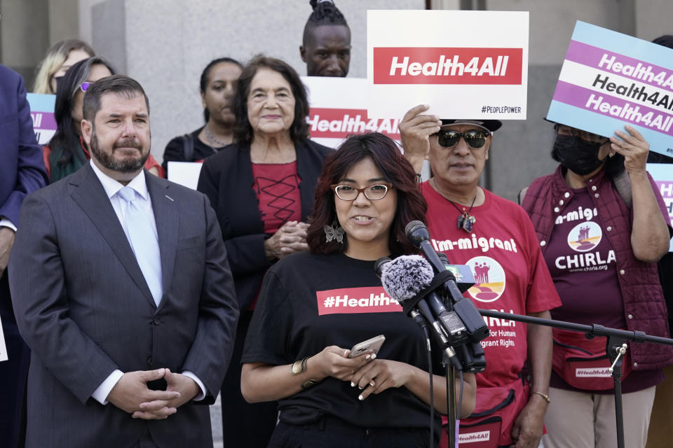 Beatriz Hernandez, center, speaks in support of health care for all low-income immigrants living in the country illegally during rally at the Capitol Sacramento, Calif., on Wednesday, June 29, 2022. Hernandez' health care insurance has fluctuated because of her immigration status. Gov. Gavin Newsom is expected to sign a $307.9 billion operating budget on Thursday June 30, 2022, that makes all low-income adults eligible for the state's Medicaid program regardless of their immigration status. (AP Photo/Rich Pedroncelli)
