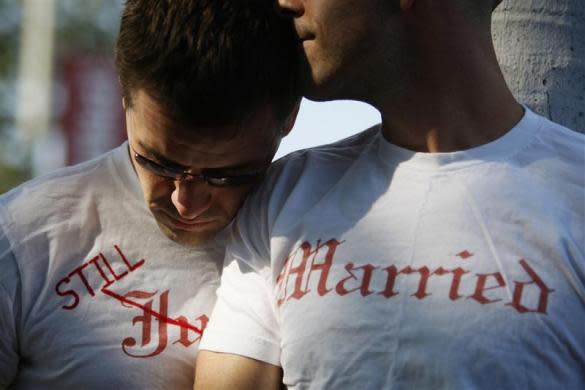 Gay couple Ethan Collings (L), 32, and his spouse Stephen Abate, 36, hug as they celebrate their one-year wedding anniversary in West Hollywood, California, June 16, 2009. The couple were married when same-sex marriages were first allowed last year.
