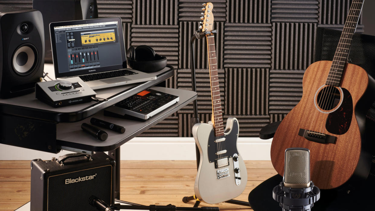  recording studio features electric guitar and amp and acoustic guitar with audio interface and laptop 