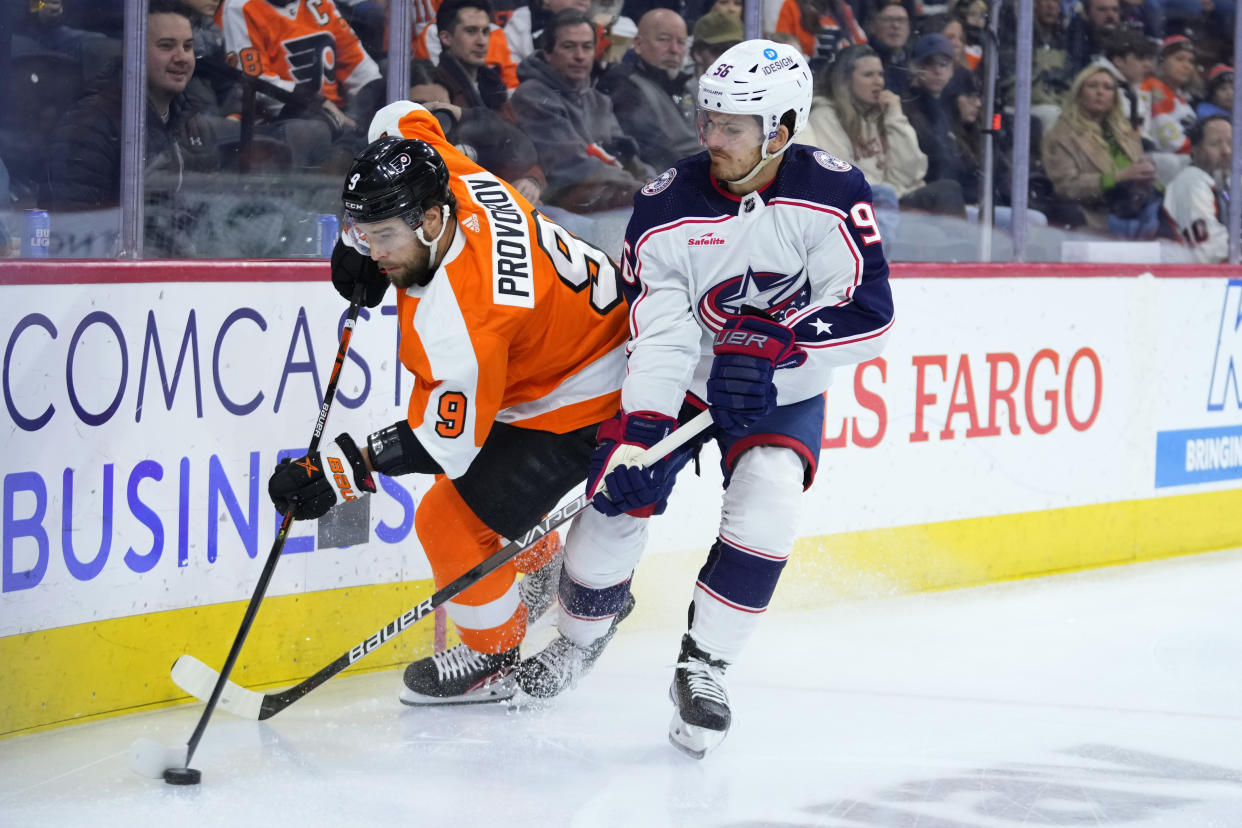 Philadelphia Flyers' Ivan Provorov, left, and Columbus Blue Jackets' Jack Roslovic battle for the puck during the first period of an NHL hockey game, Tuesday, Dec. 20, 2022, in Philadelphia. (AP Photo/Matt Slocum)