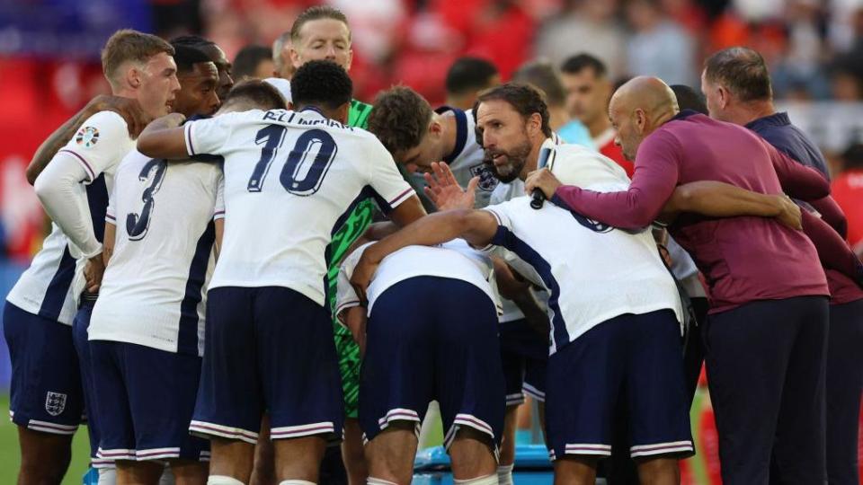 England players huddle before the penalty shoot-out