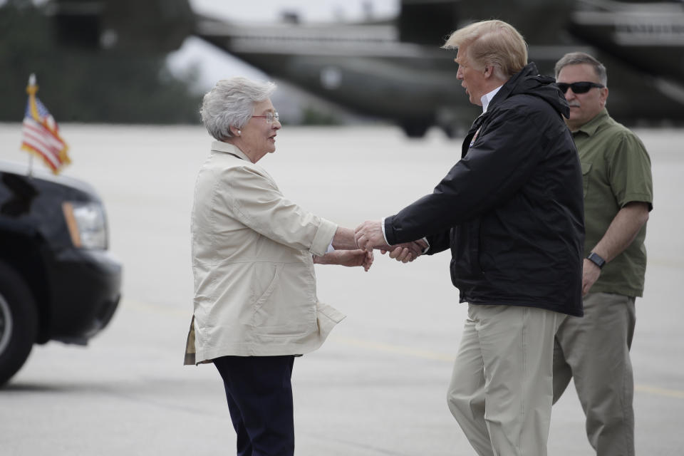 President Donald Trump is greeted by Alabama Gov. Kay Ivey on Trump's arrival, Friday, March 8, 2019, in Auburn, Ala., en route to Lee County, Ala., where tornados killed 23 people. (AP Photo/Carolyn Kaster)