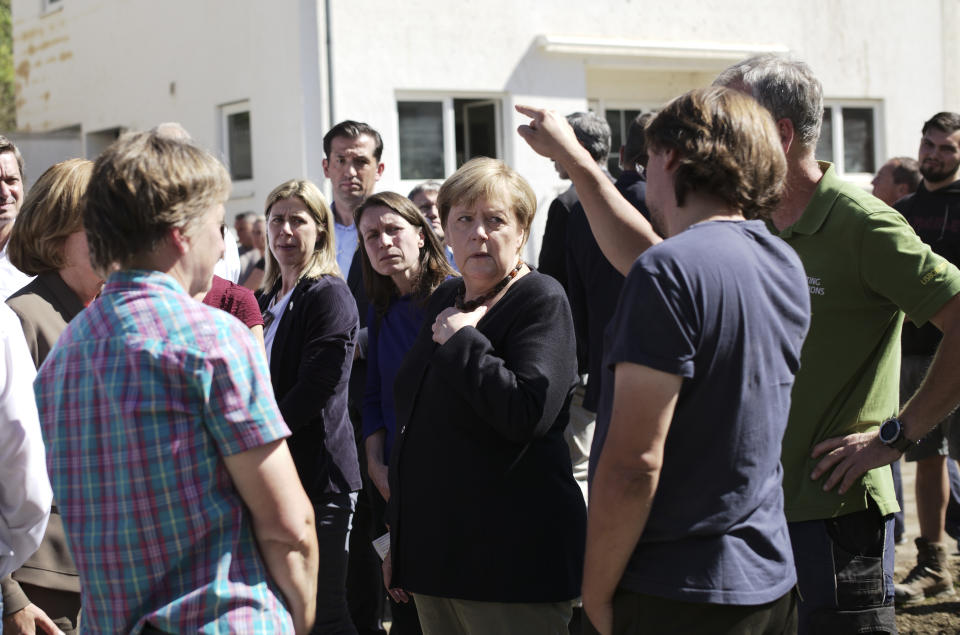 German Chancellor Angela Merkel talk to residents during her visit visit in the flood-damaged city Altenahr, Germany, Friday, Sept. 3, 2021. After days of extreme downpours causing devastating floods hit the valley of the river Ahr in July. (AP Photo/Markus Schreiber, Pool)