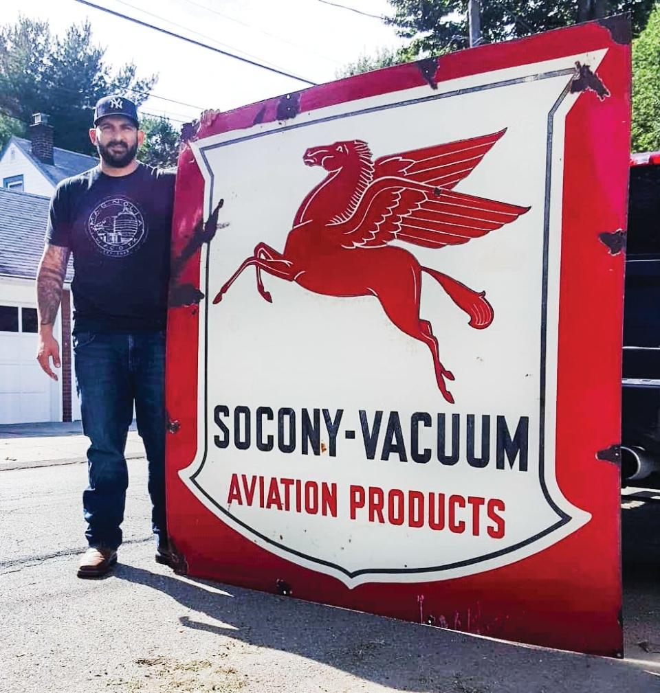 Tri-City Revivals' Chris Onorato with a giant vintage sign.