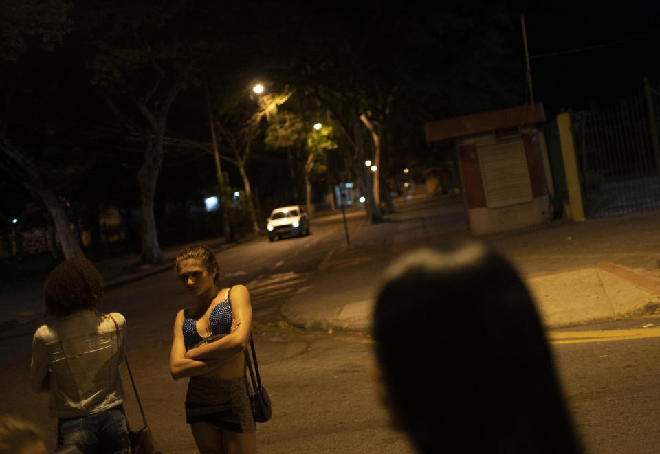 Transgender sex workers wait for customers in Niteroi, Brazil, Saturday, June 27, 2020, amid the new coronavirus pandemic. While some sex workers found refuge, others are stuck on the streets, hustling to earn enough to get by as the economy tanks. (AP Photo/Silvia Izquierdo)