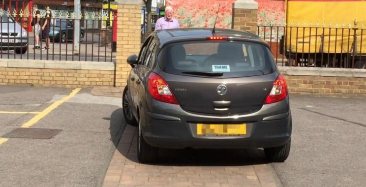 The video, filmed in a parking lot in England, shows the driver slowly trying to squeeze through a very narrow opening. Photo from YouTube.