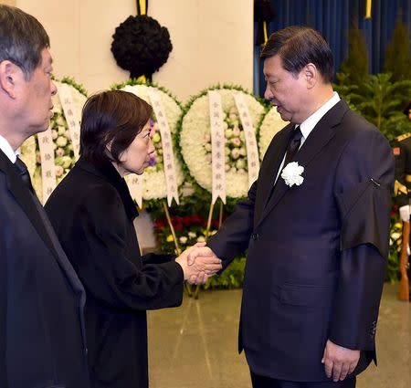 In this handout picture provided to Reuters, Chinese President Xi Jinping (R) shakes hands with relatives of Deng Liqun, a former senior official of the Communist Party of China, at Babaoshan Revolutionary Cemetery in Beijing, China, February 17, 2015. REUTERS/Li Tao/Xinhua