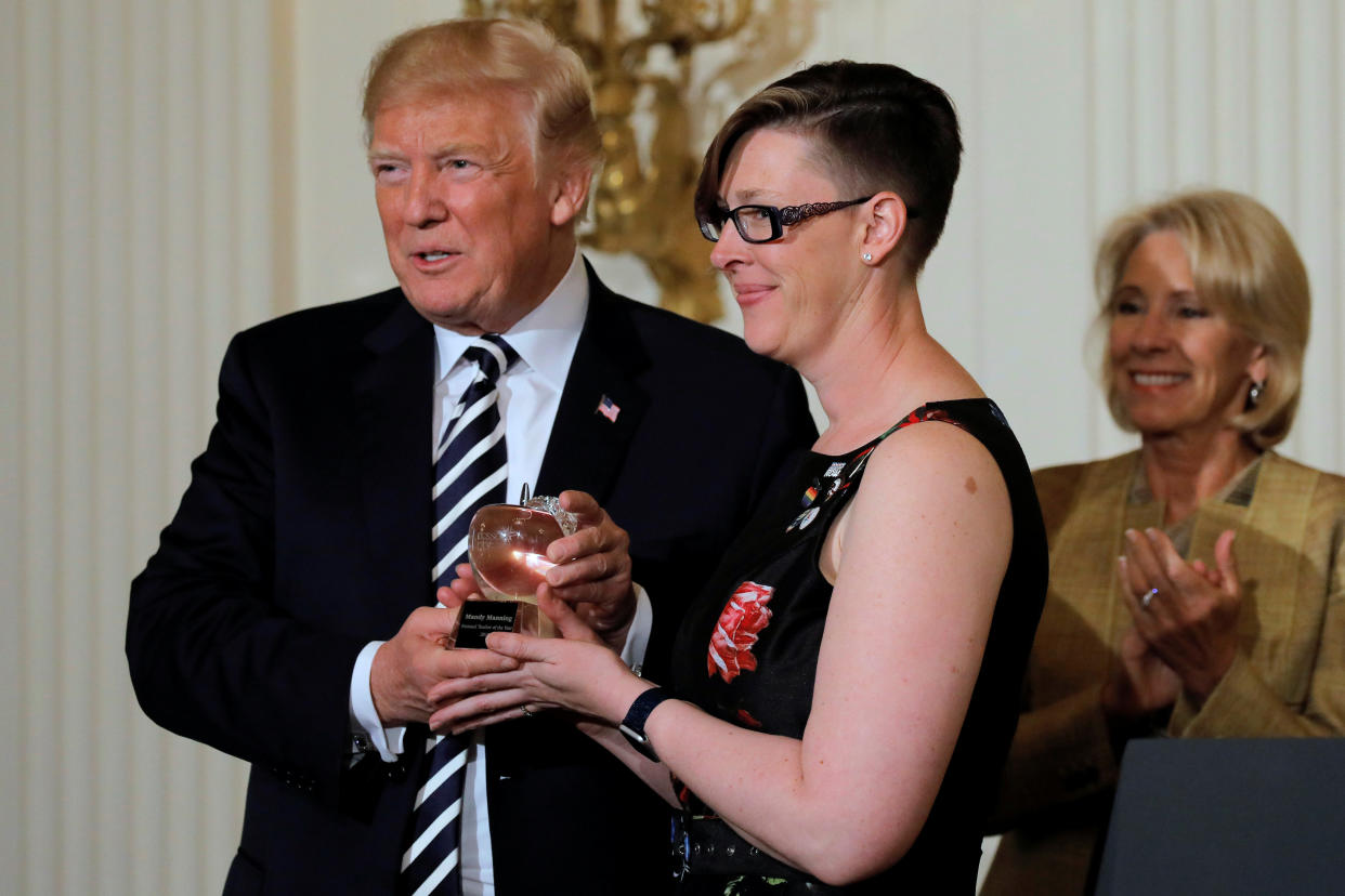 President Donald Trump presents the National Teacher of the Year Award to Mandy Manning, with&nbsp;Education Secretary Betsy DeVos at the White House, May 2. (Photo: Carlos Barria / Reuters)