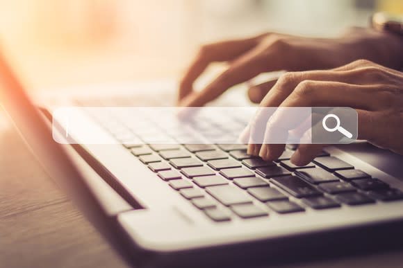 A person conducts an internet search on a laptop.