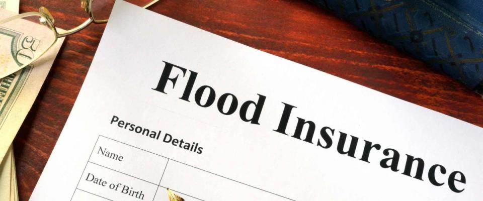 Flood insurance form on a table with a book.