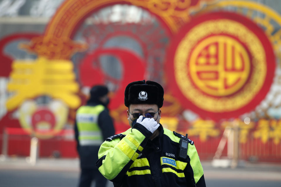 Un policía de tráfico se ajusta la mascarilla en una calle de Beijing, el domingo 9 de febrero de 2020.  (AP Foto/Andy Wong)