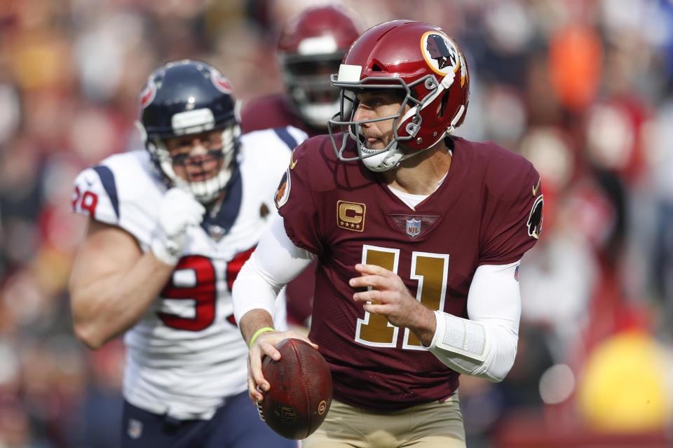 Washington Redskins quarterback Alex Smith (11) scrambles past Houston Texans defensive end J.J. Watt (99) during the first half of an NFL football game, Sunday, Nov. 18, 2018, in Landover, Md. (AP Photo/Pablo Martinez Monsivais)