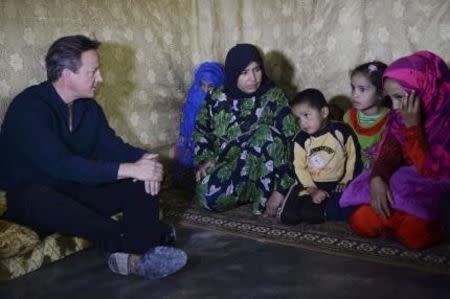 Prime Minister David Cameron meets a Syrian refugee family in a settlement camp in the Bekaa Valley in Lebanon, September 14, 2015. REUTERS/Stefan Rousseau/Pool