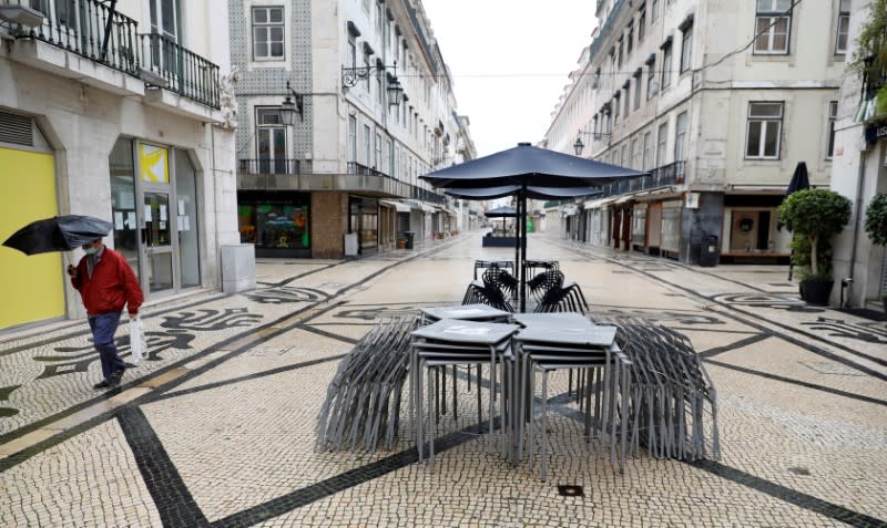 FOTO DE ARCHIVO: Un hombre con una máscara protectora como medida preventiva contra el coronavirus camina en la calle Augusta en el centro de Lisboa