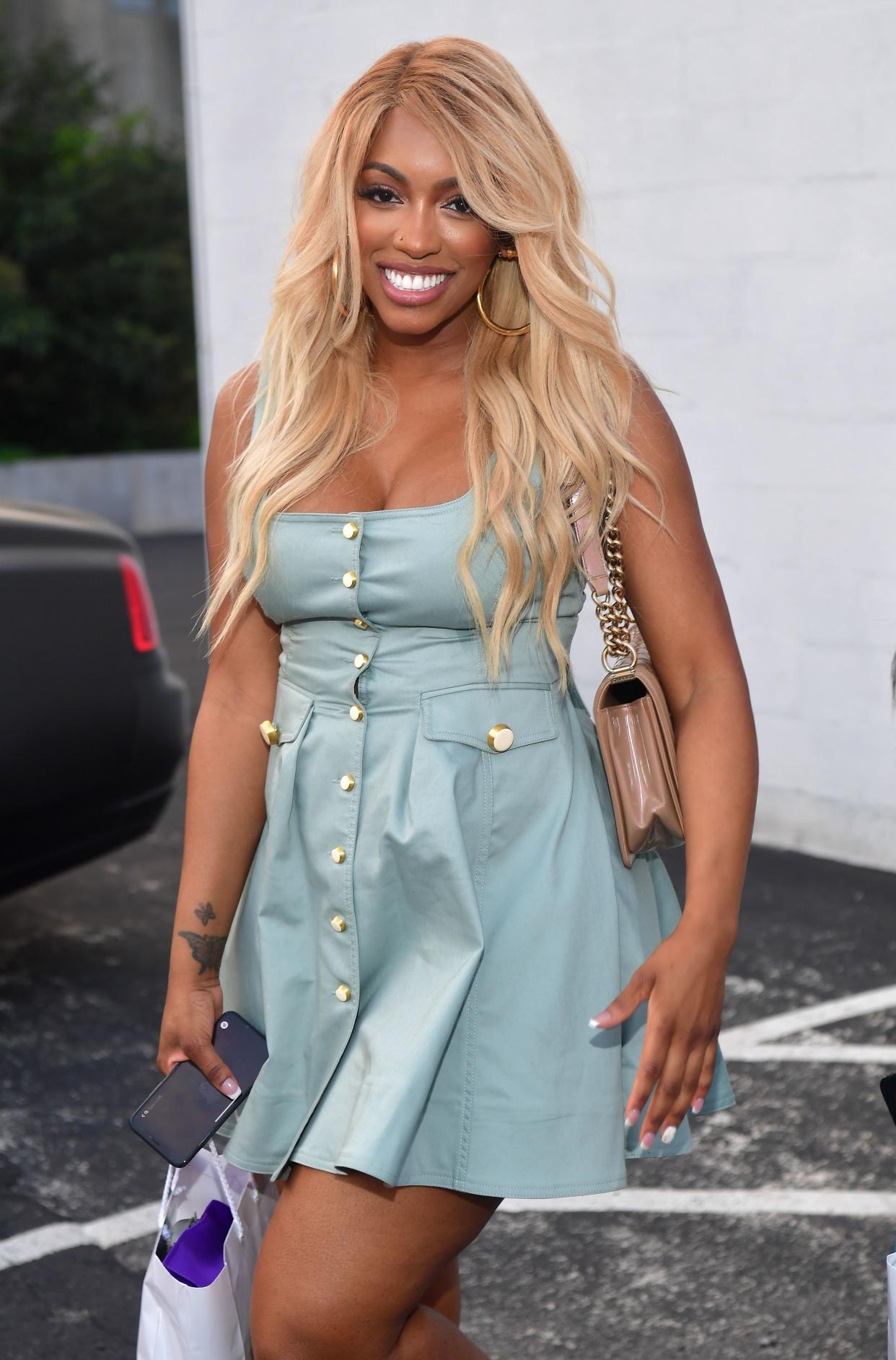 Porsha Wills looks stunning in this low-cut dress with her signature blonde hair strolling on her face-line. 