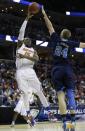 Florida forward Will Yeguete (15) shoots over UCLA forward Travis Wear (24) during the first half in a regional semifinal game at the NCAA college basketball tournament, Thursday, March 27, 2014, in Memphis, Tenn. (AP Photo/Mark Humphrey)