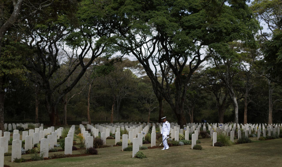 FILE - In this Sunday, Nov. 13, 2016 file photo, a Kenyan naval officer pauses as he walks amongst the graves before observing Remembrance Sunday, to honor the contribution of those British and Commonwealth military who died in the two World Wars and later conflicts, at the Nairobi War Cemetery in Kenya. The Commonwealth War Graves Commission has apologized after an investigation found that at least 161,000 mostly Africans and Indians who died fighting for the British Empire during World War I weren't properly honored due to "pervasive racism", according to findings released Thursday, April 22, 2021. (AP Photo/Ben Curtis, File)