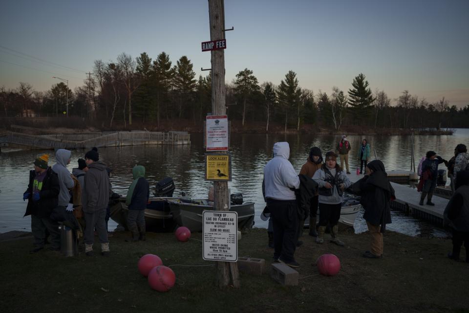 Young members of the Lac du Flambeau Band of Lake Superior Chippewa Indians wait to depart on boats to learn spearfishing during a youth spearfishing event on the Lac du Flambeau Reservation, Saturday, April 20, 2024, in Lac Du Flambeau, Wis. (AP Photo/John Locher)