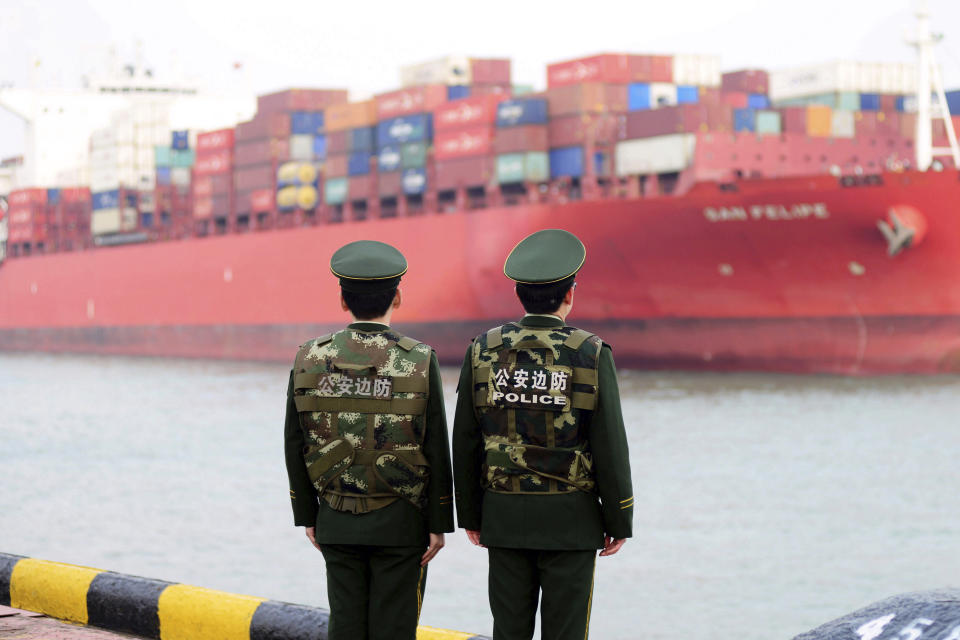 Oficiales de la policía de aduanas de China vigilan la llegada de un barco al puerto de Qingdao en la provincia de Shandong, al este del país. (Chinatopix via AP, File)