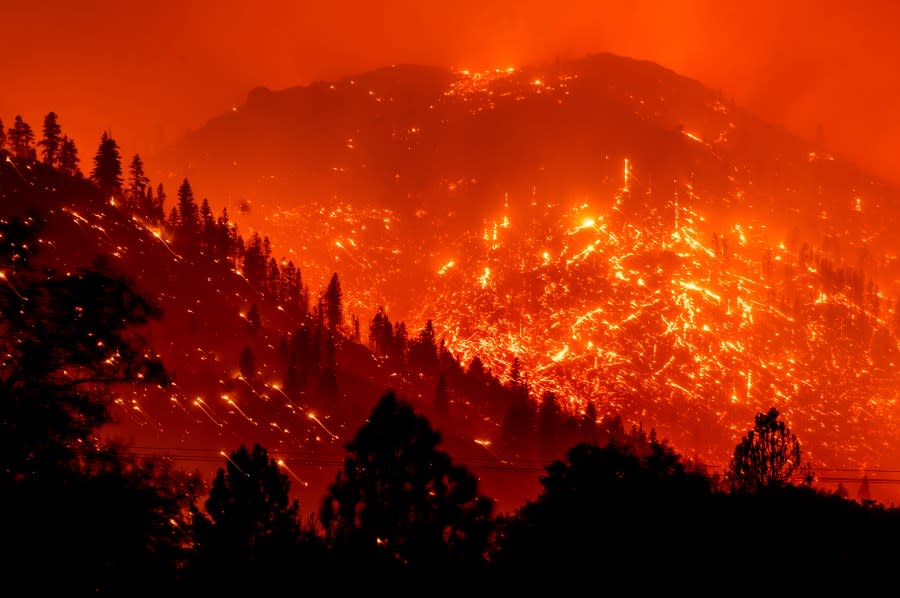 In this Aug. 17, 2021 photo, embers light up hillsides as the Dixie Fire burns near Milford in Lassen County, Calif. (AP Photo/Noah Berger, File)
