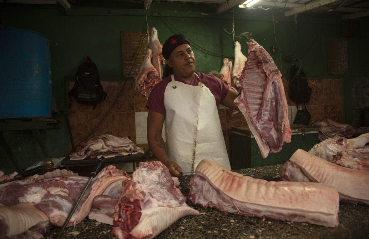 A meat vendor sells pork at a private market in Havana, Cuba, Friday, Dec. 23, 2022. (AP Photo/Ismael Francisco)