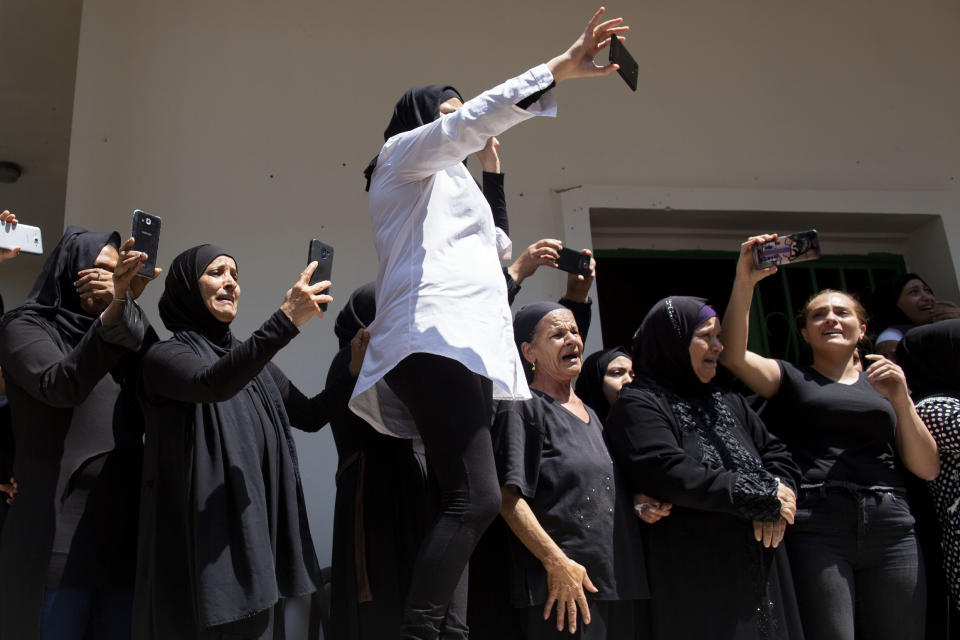 Relatives and friends of Hassan Zaher Ghosn, 14, who was killed last night, cry during his funeral procession, in Khaldeh, south of Beirut, Lebanon, Friday, Aug. 28, 2020. Clashes broke out last night between rival groups at the southern entrance of the Lebanese capital leaving two people dead and three wounded, state-run National News Agency reported. (AP Photo/Hassan Ammar)