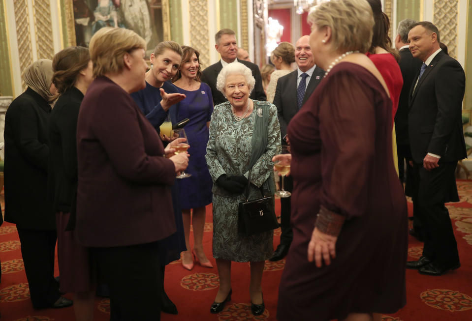 The Queen speaking to German Chancellor Angela Merkel (left) at the reception. (PA)