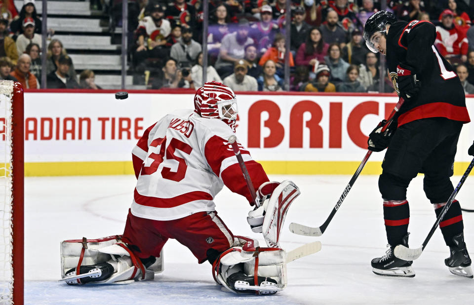 Ottawa Senators right wing Drake Batherson (19) watches a shot from defenceman Jake Sanderson (85), not shown, head to the net for a goal on Detroit Red Wings goaltender Ville Husso (35), during the first period of an NHL hockey action in Ottawa, Ontario, Saturday, Oct. 21, 2023. (Justin Tang/The Canadian Press via AP)