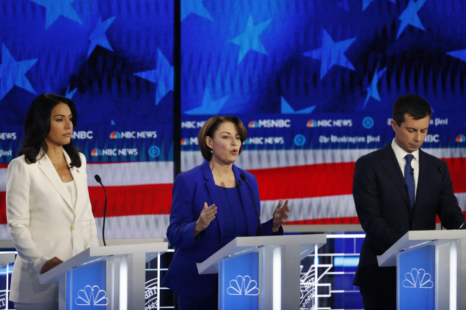 Democratic presidential candidate Sen. Amy Klobuchar, D-Minn., center, speaks as South Bend, Ind., Mayor Pete Buttigieg and Rep. Tulsi Gabbard, D-Hawaii, listen during a Democratic presidential primary debate, Wednesday, Nov. 20, 2019, in Atlanta. (AP Photo/John Bazemore)